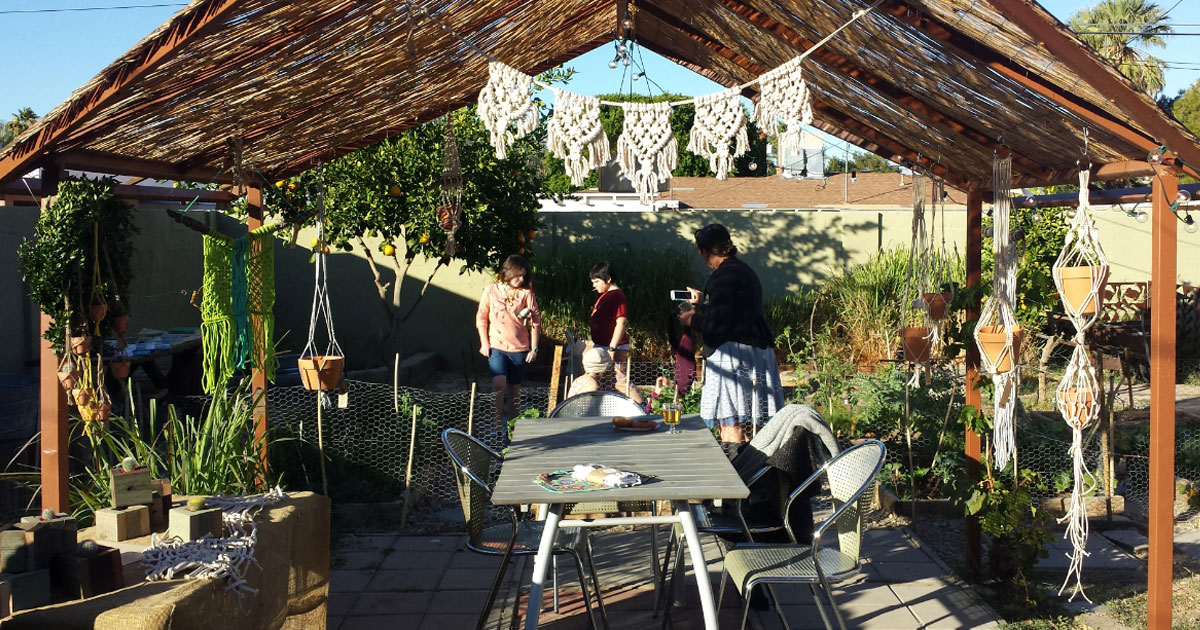 Mojave Macrame garland and hanging planters are hanging from a backyard gazebo